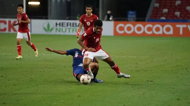 Pemain Timnas Indonesia Ricky Kambuaya berebut bola dengan pemain Singapura di leg kedua semifinal Piala AFF 2020 yang digelar di Stadion Nasional, Sabtu (25/12/2021). (Foto: Dok. PSSI)