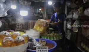 Pedagang menata minyak goreng di tokonya di Pasar Minggu, Jakarta, Rabu (26/1/2022). (Foto: Suara.com/Angga)