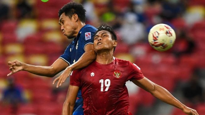 Penyerang Thailand, Teerasil Dangda (kiri) dan pemain Indonesia Fachruddin Wahyudi Aryanto pada pertandingan leg kedua final Piala AFF 2020 di Stadion Nasional Singapura pada 1 Januari 2022. (Foto: Roslan RAHMAN/AFP)