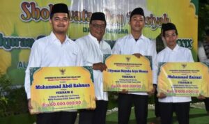 Gubernur Kalsel H Sahbirin Noor atau Paman Birin (dua kiri) secara simbolis menyerahkan bonus bagi anggota kafilah asal Kalsel yang mendapat juara di MTQN, Rabu (9/11/2022) malam di Desa Kiram Karang Intan Kabupaten Banjar. (Foto: Adpim Setdaprov Kalsel)