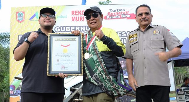 Gubernur Kalsel H Sahbirin Noor atau Paman Birin (tengah) menerima penghargaan rekor Museum Rekor Indonesia (MURI), turdes terpanjang 1000 Km dengan mengendarai motor trail, Senin (7/11/2022) di Kiram Park Desa Kiram. (Foto: Adpim Setdaprov Kalsel)