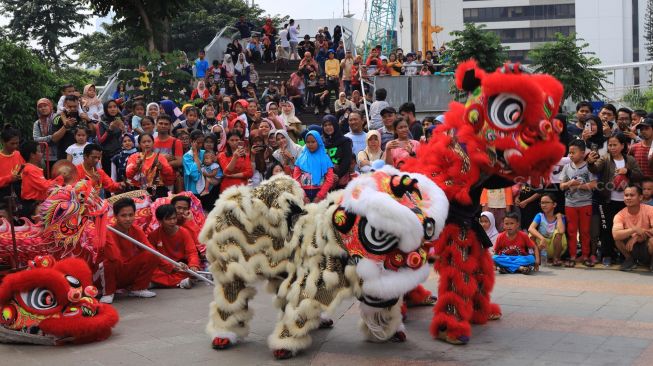 Sejumlah seniman beraksi memainkan barongsai saat berlangsungnya Car Free Day di Bundaran Hotel Indonesia, Jakarta, Minggu (26/1/2022). (Foto: Suara.com/Alfian Winanto)