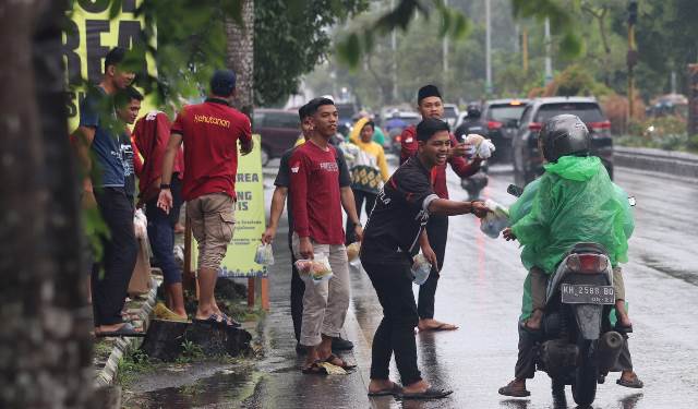 Rimbawan Dishut Kalsel membagikan konsumsi bagi jemaah haul ke 18 Guru Sekumpul, Kamis (26/1/2023) siang. (Foto: Dishut Kalsel)