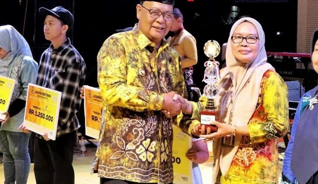 Kepala Dinas Kehutanan (Dishut) Provinsi Kalimantan Selatan (Kalsel) Hj. Fathimatuzzahra (kanan) nampak terharu ketika menerima penghargaan dari Gubernur Kalsel H Sahbirin Noor pada penutupan Kalsel Expo 2023 di Lapangan Murjani Kota Banjarbaru, Minggu (3/9/2023) malam. (Foto: Dinas Kehutanan Kalsel/Katajari.com)