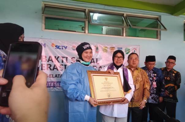 Menteri Sosial, Risma memberikan simbolis penghargaan kepada dokter operasi katarak, Kamis (21/9/2023)di RSUD Ratu Zalecha Martapura. (Foto: Katajari.com)