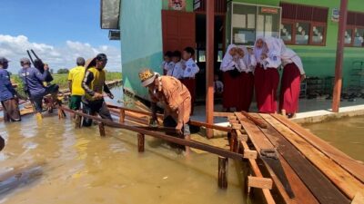 Akses Menuju SDN Sungai Batang Ilir Terendam Banjir, Orang Tua Siswa Bangun Jembatan Darurat